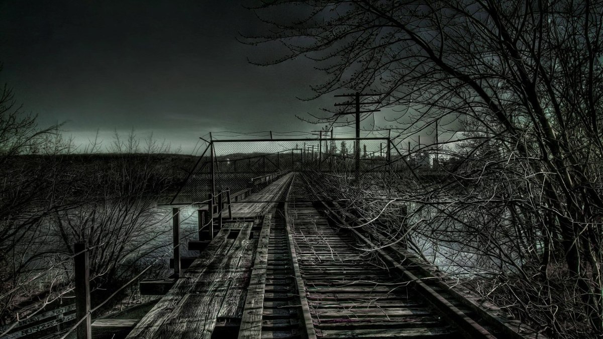 A landscape of a decrepit and abandoned wooden railway, with dead leafless trees on either side and a dark sky with only a faint, thin, blurred line of light in the distance. Creepy, haunted atmosphere.
